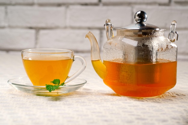 Close-up of drinks with cup and teapot on table