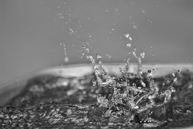 Photo close-up of drop falling on water