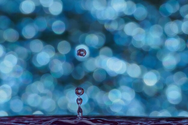 Photo close-up of drop falling on water