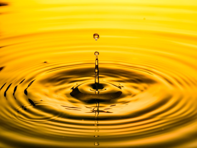 Close up of a drop oil on a yellow background