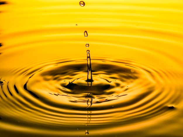 Close up of a drop oil on a yellow background