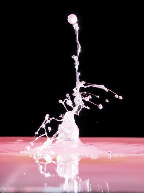 Foto close-up di una goccia in acqua rosa