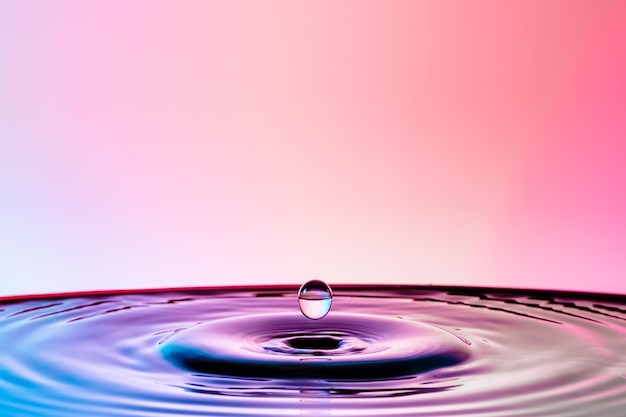 色の背景に水にスプラッシュする水滴のクローズアップ
