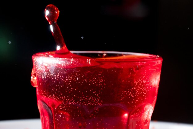 Close-up of drops falling in alcohol against black background