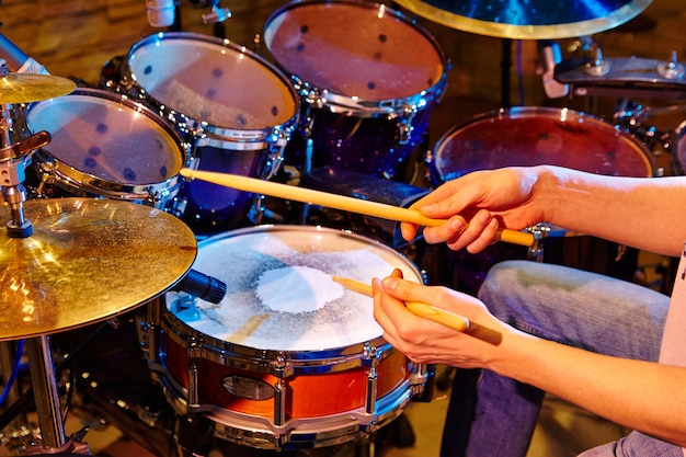 Close Up Of Drummer Playing Drum Kit In Studio