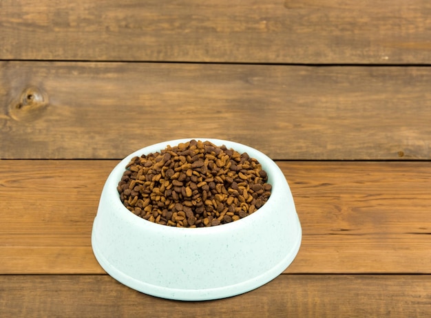 Photo a close up of dry cat food in a white ceramic bowl on a white background