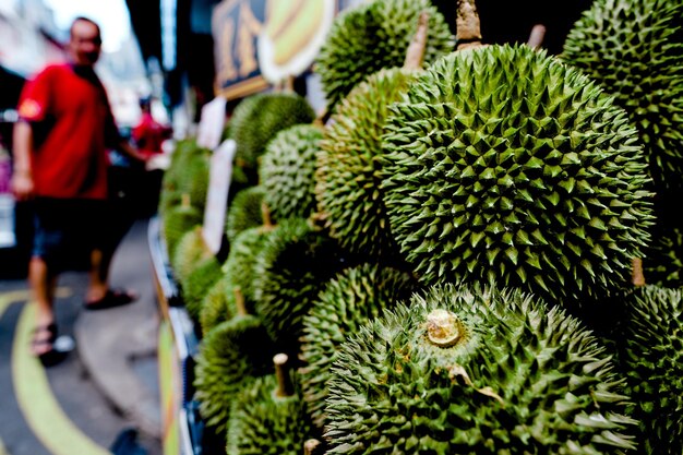 Close-up of durian by man at market stall