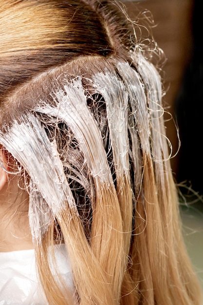 Foto primo piano di tintura sui capelli della giovane donna.