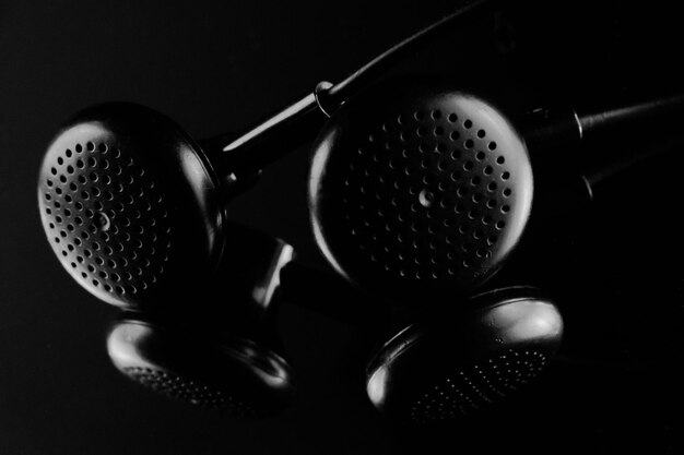 Close-up of in-ear headphones against black background