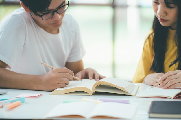 Close-up een Aziatische studenten lezen boeken en studeren samen Tutoring