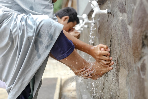 Close-up Een islamitische kostschoolstudent doet wassing en wast zijn voeten