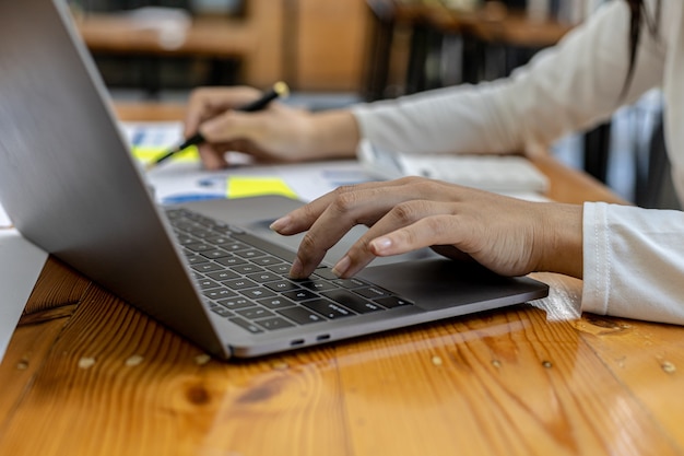 Close-up een zakenvrouw die in een privékamer werkt, ze typt op een laptoptoetsenbord, ze gebruikt een messenger om met een partner te chatten. concept van het gebruik van technologie in communicatie.