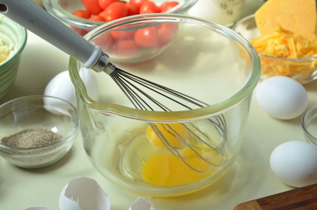 Photo close-up of egg yolk with wire whisk in container