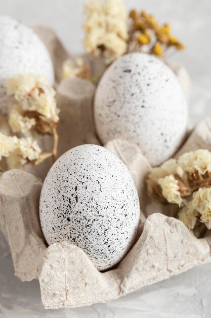 Close-up of eggs for easter in carton with flowers