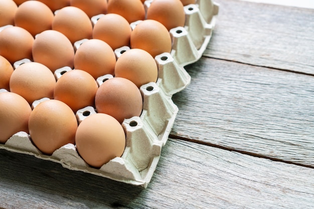 Close up of eggs in the paper tray on wooden table