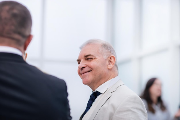 Close up elderly businessman talking to his colleague