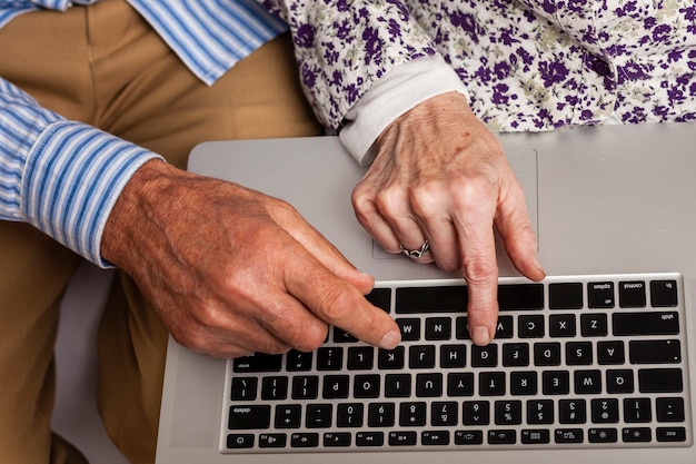 Foto coppie anziane del primo piano che per mezzo di un computer portatile