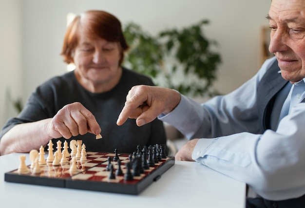 Photo close up elderly playing chess indoors