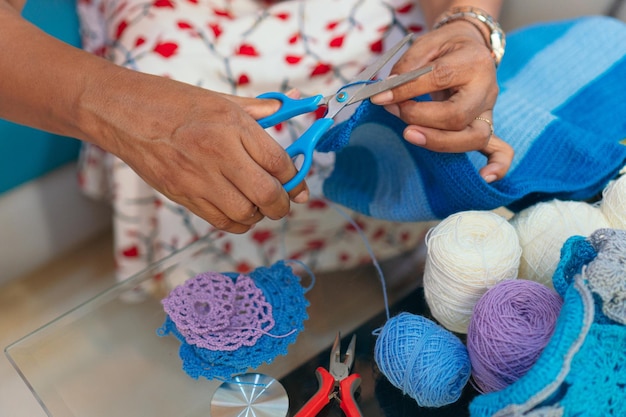自宅で編み物をしている年配の女性のクローズアップ