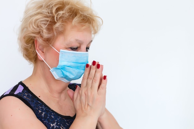 Close-up elderly woman with a medical mask on her face. The global problem of coronavirus.