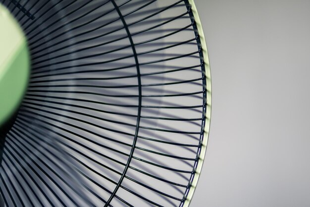 Photo close-up of electric fan against white wall