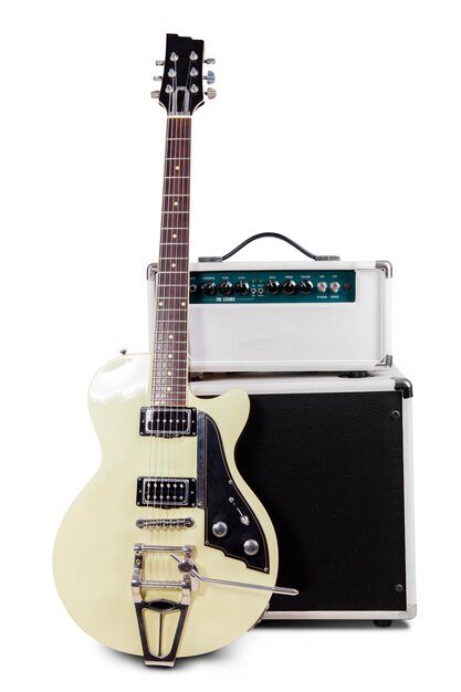 Photo close-up of electric guitar by equipment on speaker against white background