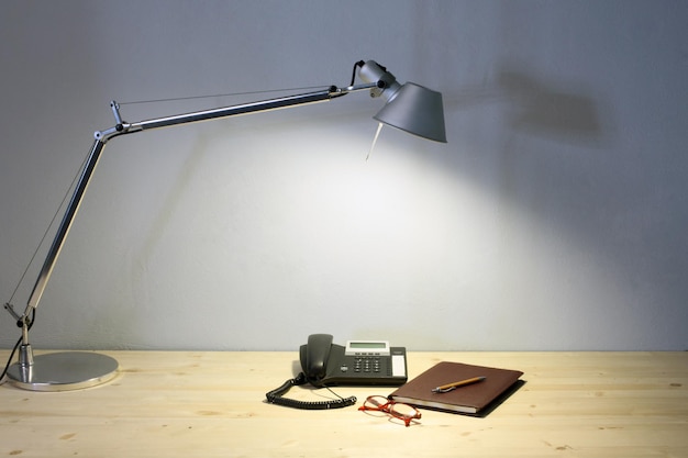 Close-up of electric lamp on table against wall