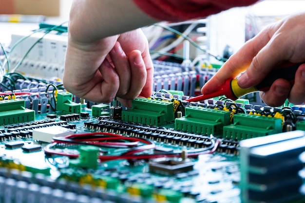 Photo close up of electrician working with cables and wires on the assembly line the installation of the transformer