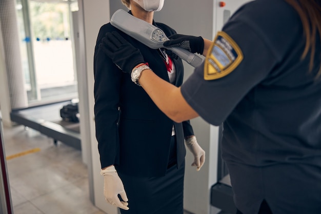 공항 터미널에서 비행하기 전에 보안 검사를 통과하는 우아한 사업가의 닫습니다