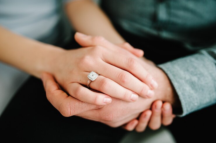 Photo 女性の指の愛と結婚式のコンセプトにエレガントな婚約ダイヤモンドリングのクローズアップ