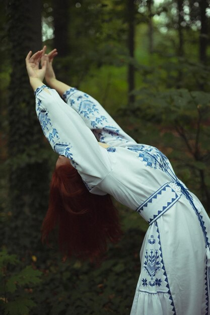 Close up elegant woman in embroidered dress leaning back\
concept photo