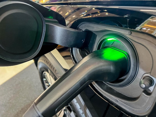 Foto close-up elektrische stekker opladen van een ev-auto bij een oplaadstation voor elektrische voertuigen