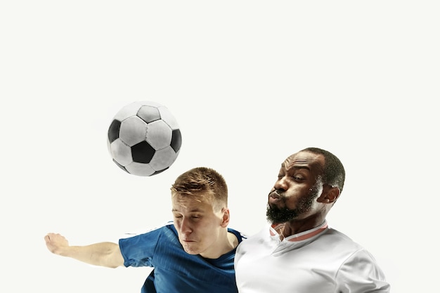 Chiuda in su degli uomini emotivi che giocano a calcio colpendo la palla con la testa isolata sul muro bianco. calcio, sport, espressione facciale, concetto di emozioni umane. copyspace. combatti per l'obiettivo.