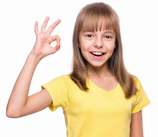 Close-up emotioneel portret van aantrekkelijk blank meisje Mooi gelukkig schoolmeisje dat ok gebaren maakt en naar de camera kijkt Grappig schattig glimlachend kind geïsoleerd op witte achtergrond