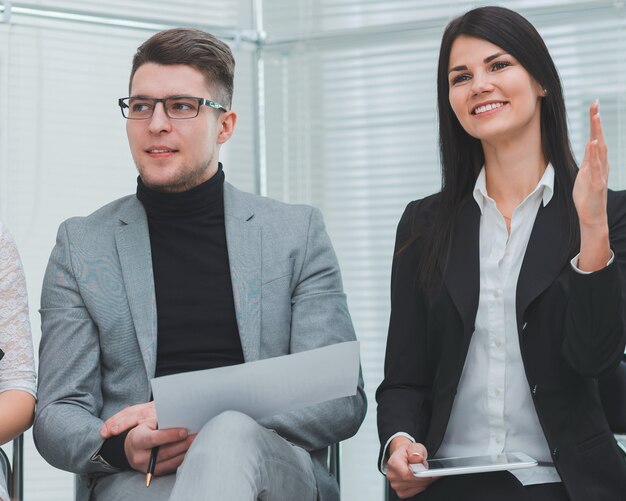 Close up employees asking questions at a work meeting