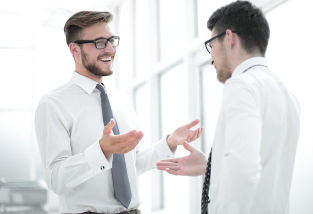 Close up employees talk standing in a spacious officebusiness concept