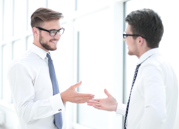 Close up employees talking standing near the office windowbusiness concept