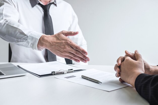 Foto primo piano del datore di lavoro pronto a stringere la mano del dipendente