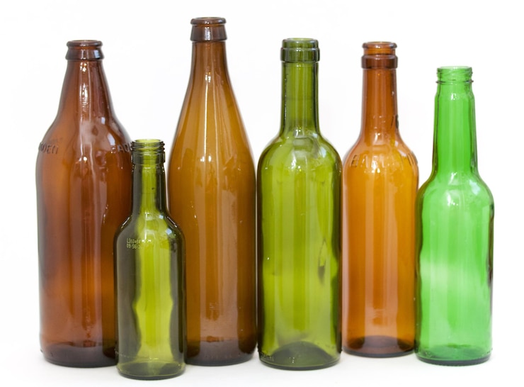 Photo close-up of empty bottles against white background