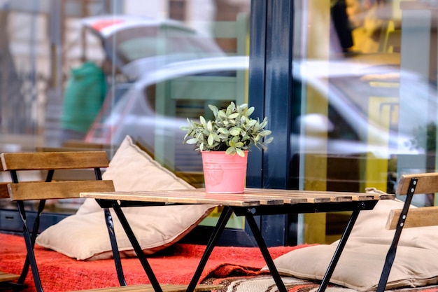 Photo close-up of empty chairs and table at sidewalk cafe