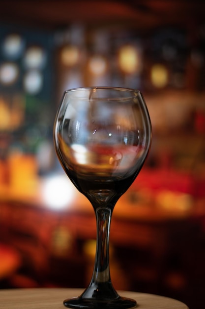 Close up of empty glass of wine in a vintage bar over a table and copy space