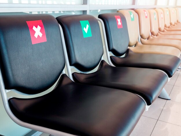 Close-up empty waiting chairs with social distancing sign