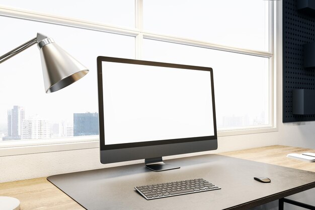 Close up of empty white computer display on wooden office desk
top with objects lamp and supplies on panoramic window and city
view backdrop mock up 3d rendering