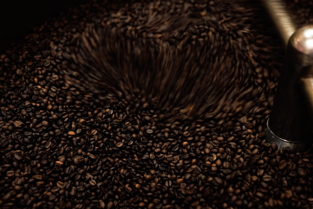 Close-up en sluitertijd met lage snelheid zijn wazig om de beweging van donker gebrande koffiebonen vast te leggen