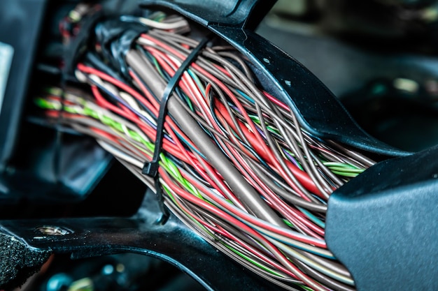 Close up of the engine control unit of the car multicolored wires plug a wiring of a truck car