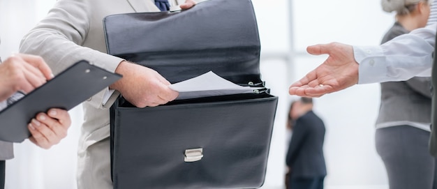 Close up. entrepreneur handing documents to the Bank employee. business concept