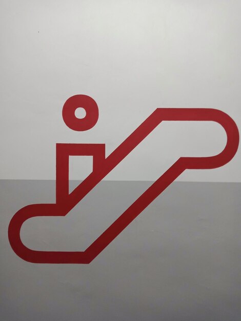 Photo close-up of escalator sign against gray wall