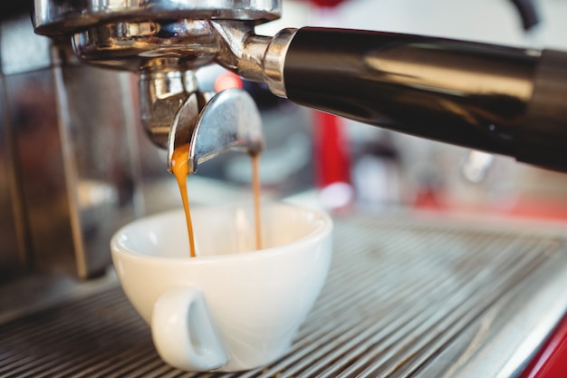 カフェでコーヒーを注ぐエスプレッソメーカーのクローズアップ