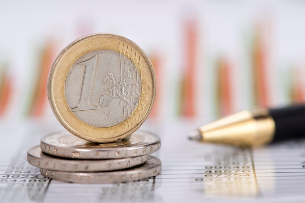 Close-up of european union coins with pen on paper