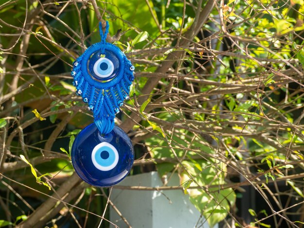 Close up of evil eye charms hang from a tree